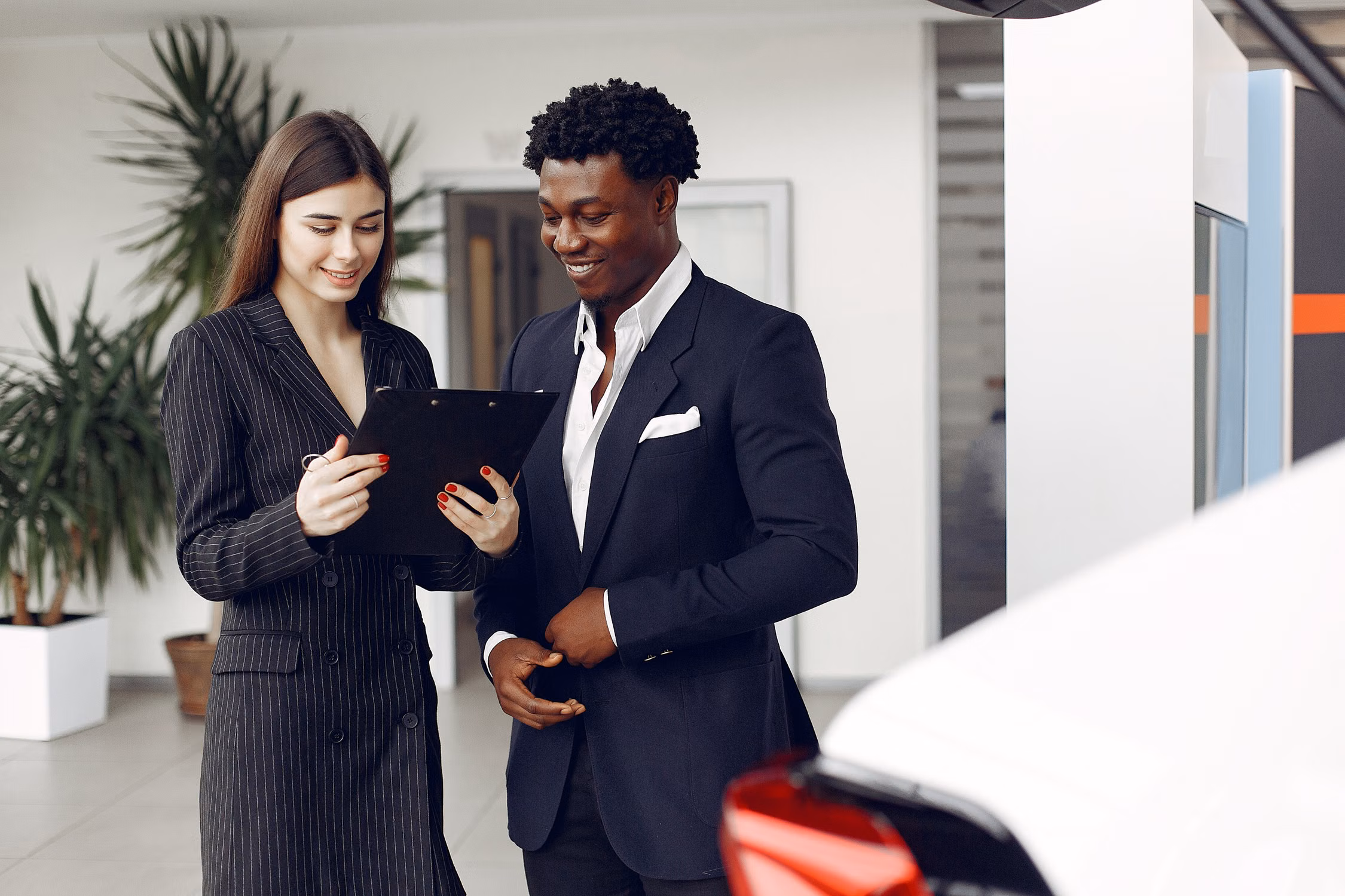 Conseillère automobile échangeant avec un client dans un showroom